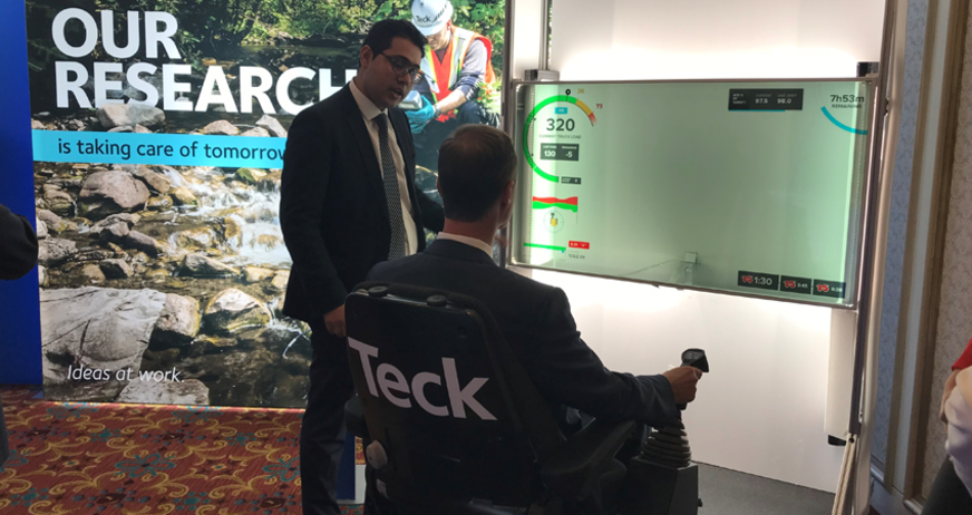 Demonstration of research technology with interactive display at an exhibition, two men present.
